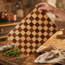 Square wood board with a checkerboard pattern in contrasting light and dark wood tones.