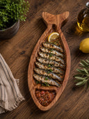 Long fish-shaped wood platter used to serve fish, lemon and an accompaniment.