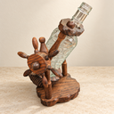Nautical wooden bottle holder with its ship-wheel detail and clear glass bottle shown tilted.