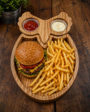 Owl-shaped wood platter holding a burger, fries and sauces in separate compartments.
